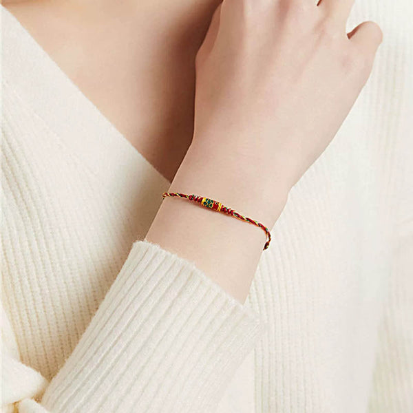 Koi Fish Wealth Bracelet – Red rope bracelet worn on wrist with koi charm, protection amulet