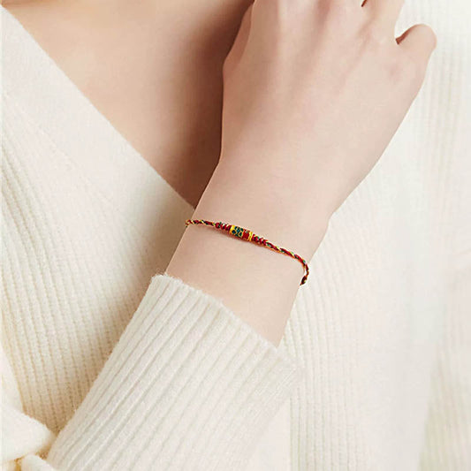 Koi Fish Wealth Bracelet – Red rope bracelet worn on wrist with koi charm, protection amulet