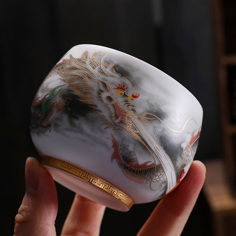 Dragon Gilt Porcelain Teacup - Jade-white cup with gold dragon outline in hand, exquisite