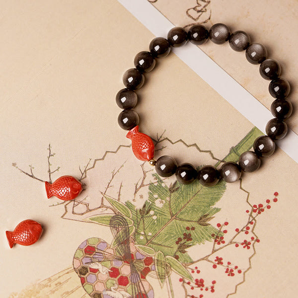 Silver Sheen Obsidian Bracelet – close-up koi fish cinnabar carving, shiny obsidian stones