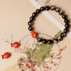Silver Sheen Obsidian Bracelet – close-up koi fish cinnabar carving, shiny obsidian stones