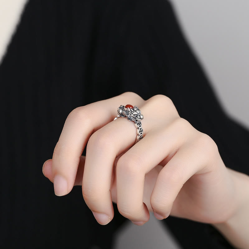 PiXiu Red Agate Wealth Ring worn on finger, silver beast detail, carnelian stone, dark background, lucky ring