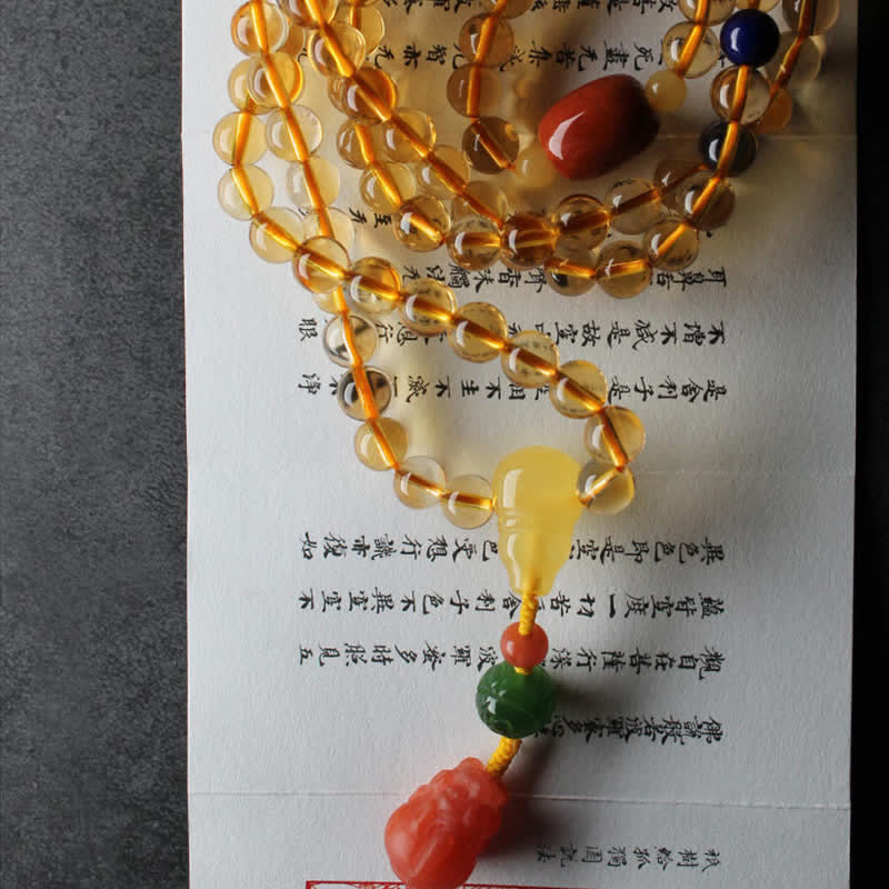 Citrine Mala Bracelet – Citrine mala on calligraphy book with carved red coral PiXiu charm