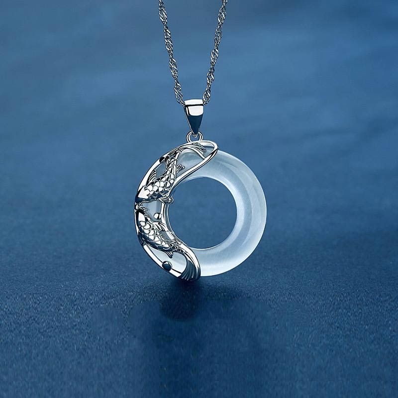 Silver koi fish necklace with translucent white jade circle pendant, twin carp yin-yang design on Singapore chain, aquatic blue setting