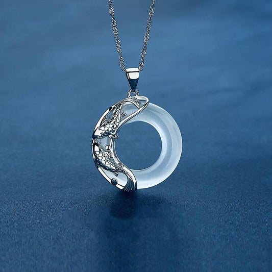 Silver koi fish necklace with translucent white jade circle pendant, twin carp yin-yang design on Singapore chain, aquatic blue setting