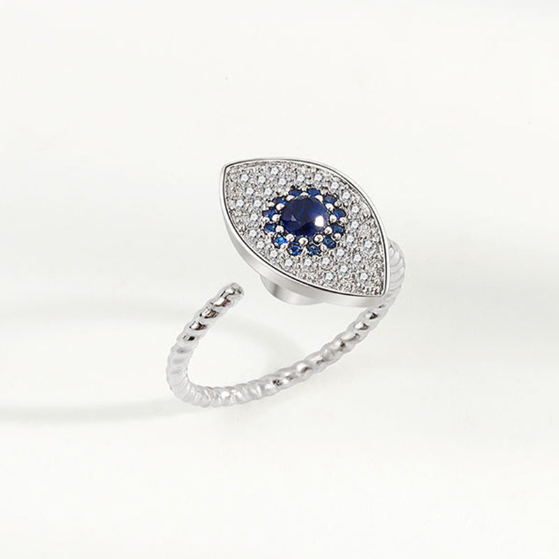 Evil Eye Rotatable Ring – Silver evil eye ring on woman hand, blue crystal center, twisted band