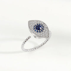 Evil Eye Rotatable Ring – Silver evil eye ring on woman hand, blue crystal center, twisted band