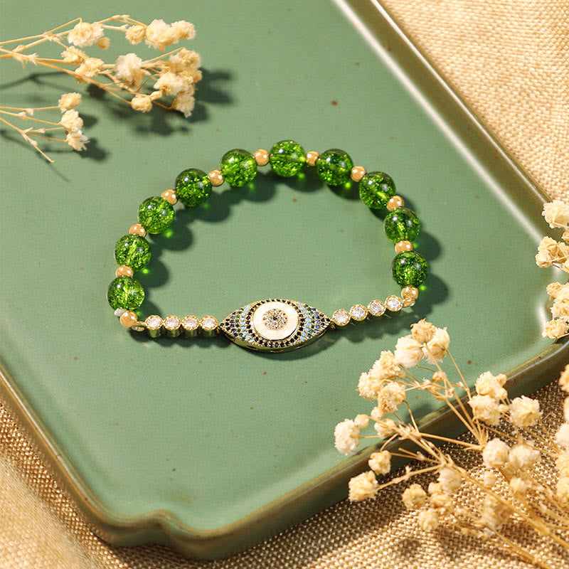 Evil Eye Bundle – Green crystal bead bracelet with gold evil eye pendant on ceramic tray, boho styling