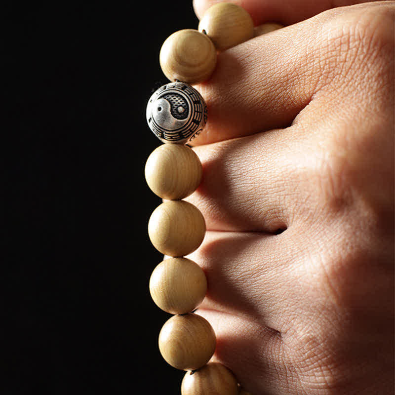 Peach Wood Cinnabar Bracelet – Macro view of yin yang bead detail on wooden prayer beads, zen accessory