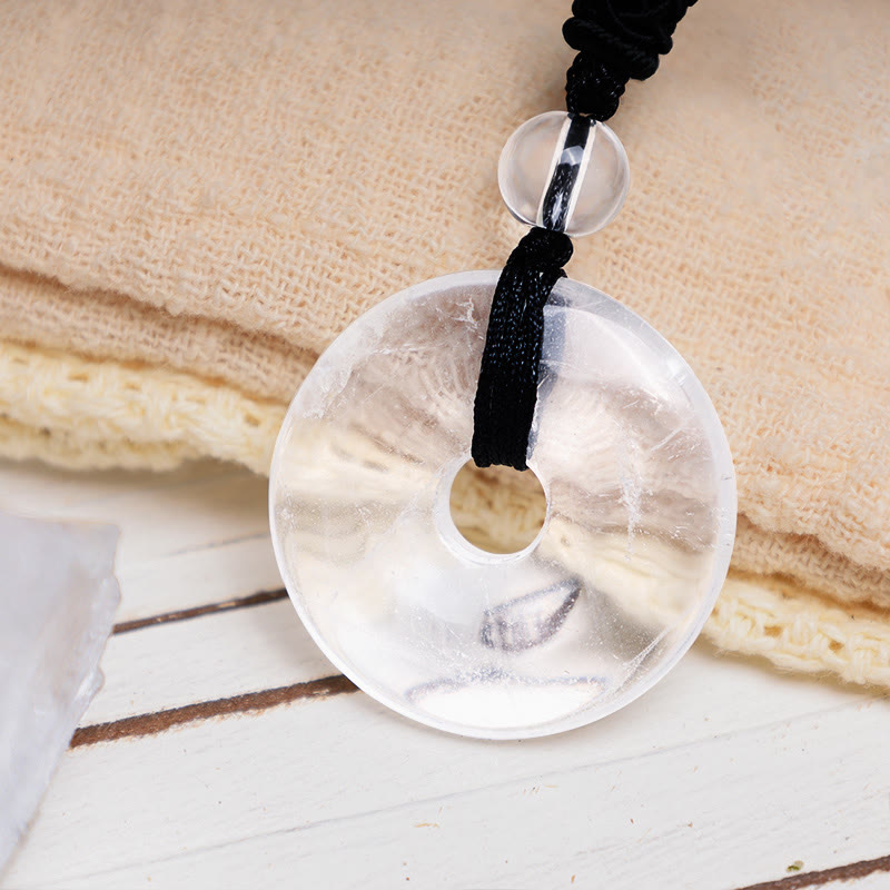 Lucky Coin Pendant Healing Crystal Gemstone Necklace – Clear quartz donut necklace worn over white shirt and gray jacket
