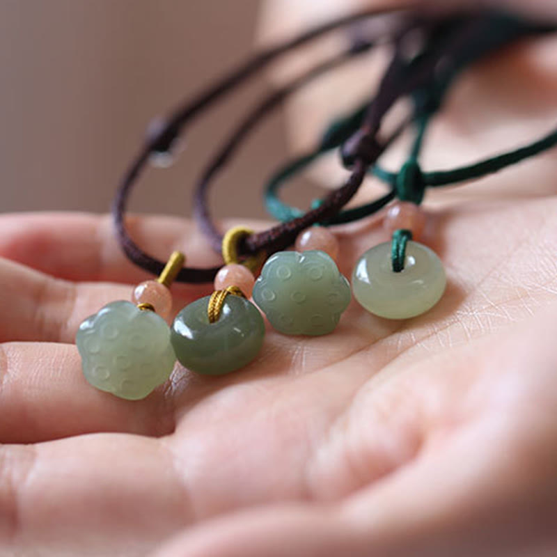 Jade Peace Buckle Lotus Necklace – Four jade pendant necklaces with lotus pod and bi-disc in open palm, jade set