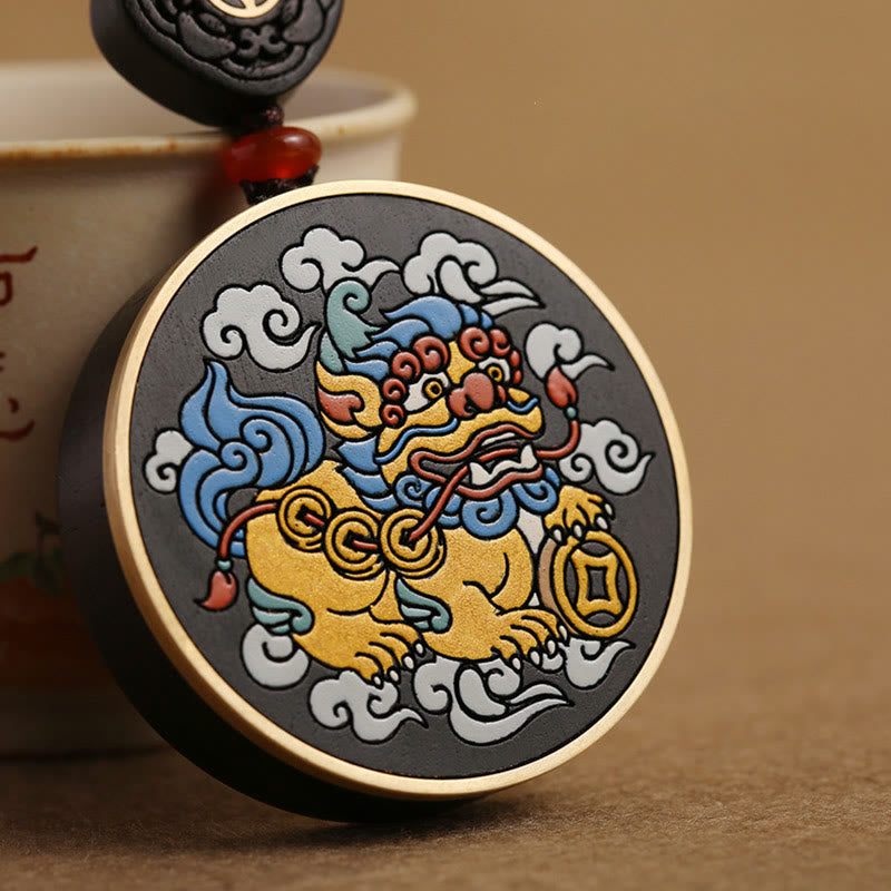 PiXiu Coin Keychain – Close-up of hand-painted PiXiu with cloud motifs on black medallion