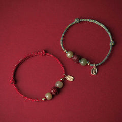 Hetian Jade Cinnabar Lotus Bracelet – Red and teal cord variants paired on crimson background, dual color bracelet