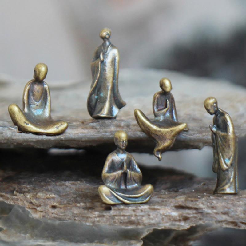 Mini Metal Meditation Buddha Decoration – front view of five brass meditation figurines on rocks, tranquility and balance