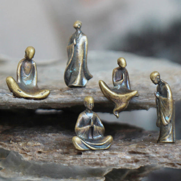 Mini Metal Meditation Buddha Decoration – front view of five brass meditation figurines on rocks, tranquility and balance