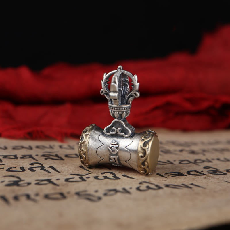 925 Silver Dorje Bell Pendant – Silver vajra pendant on Tibetan manuscript with red silk backdrop
