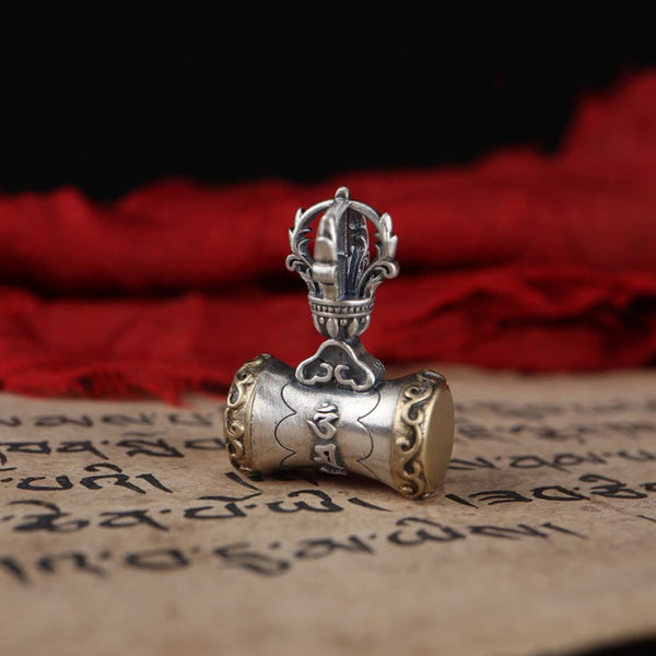 925 Silver Dorje Bell Pendant – Silver vajra pendant on Tibetan manuscript with red silk backdrop