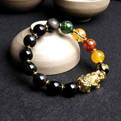 Color-Changing PiXiu Obsidian Five Elements Bracelet – styled on stone stand with ceramic cups background, five elements jewelry