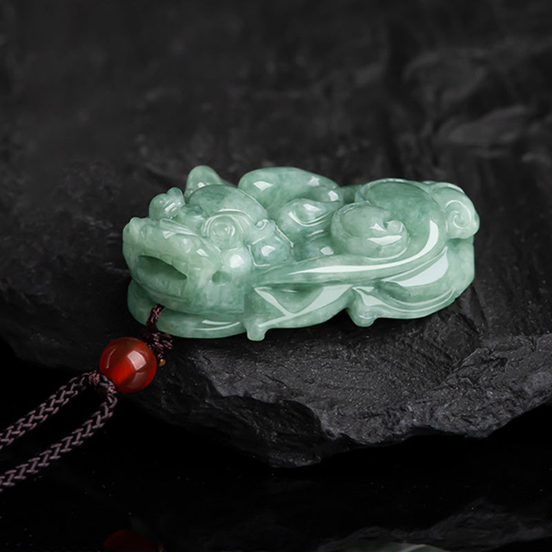 Jade PiXiu Necklace – Side view pale green jade Pixiu with carnelian bead on dark rock, abundance talisman