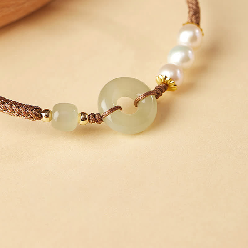 Hetian Jade Pearl Peace Buckle Bracelet – jade bi disc and pearl detail macro, gold accents and braided cord, neutral background