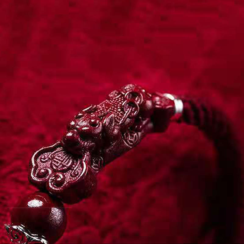 Handcrafted PiXiu Cinnabar Wealth Luck Braided Bracelet – extreme close-up of PiXiu head carving on velvet, beast