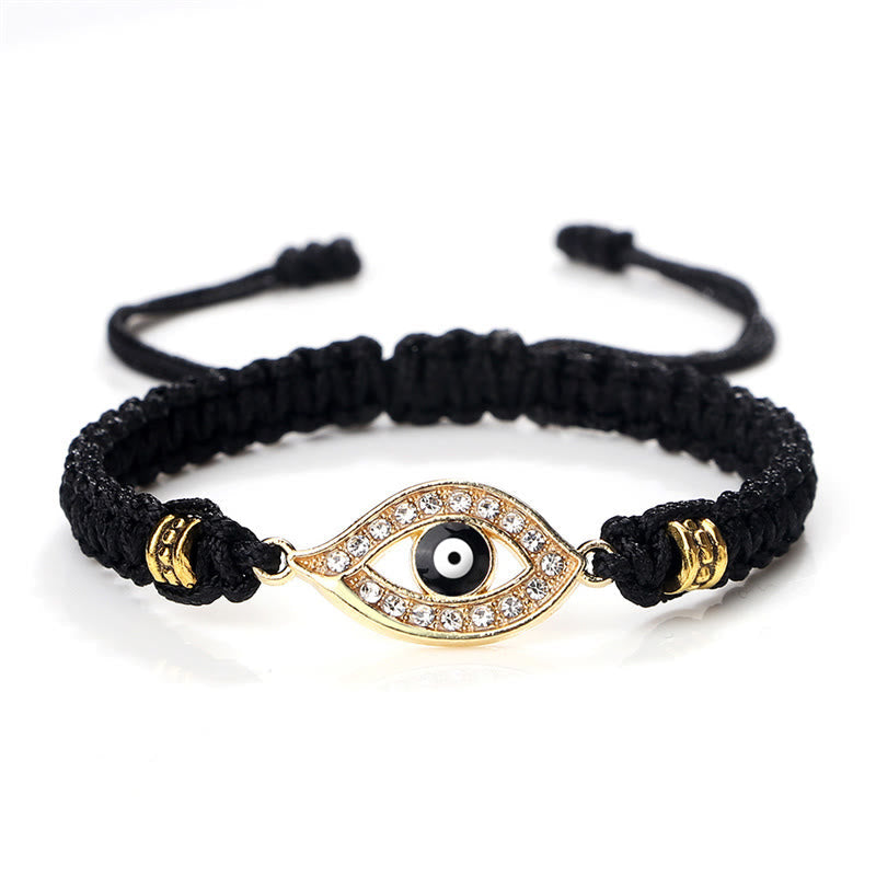 Black cord evil eye bracelet with gold crystal pave charm on white background