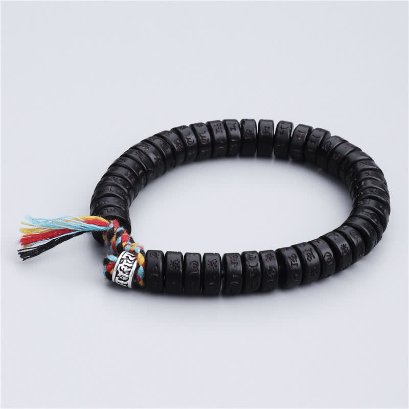 Coconut Shell Mantra Bracelet - Flat lay showing coconut bead engraving detail and braided cord, prayer jewelry
