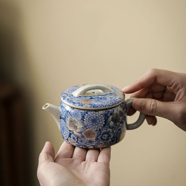 Lotus Chrysanthemum Ceramic Teapot - Two-hand hold showing dense floral pattern, compact brewing