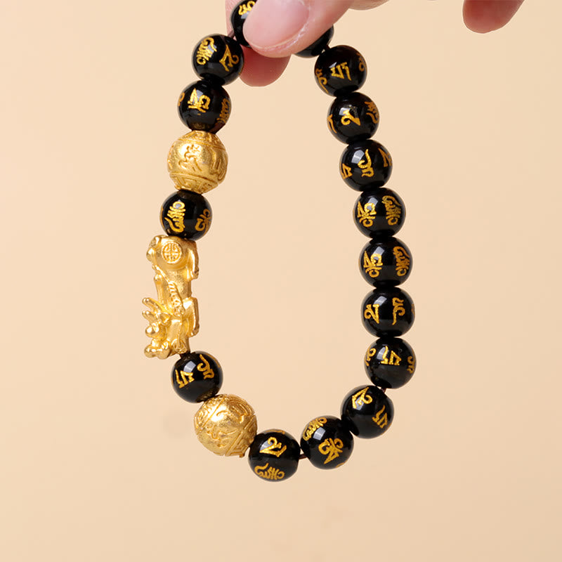 FengShui PiXiu Obsidian Bracelet – held by fingers vertical view beige background, FengShui PiXiu jewelry