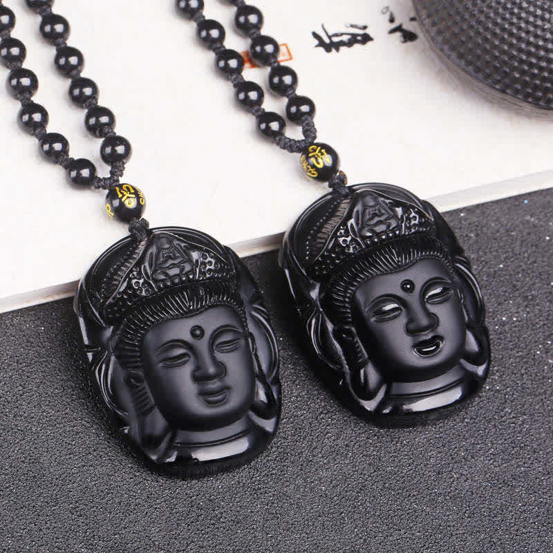 Black Obsidian Avalokitesvara Pendant - pair of carved Guanyin pendants with gold mantra beads, flat lay, Strength