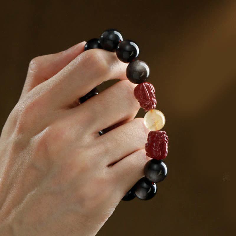 Gold Sheen Obsidian Pixiu Bracelet – hand grip side view, red cinnabar pixiu charm and golden quartz bead close-up