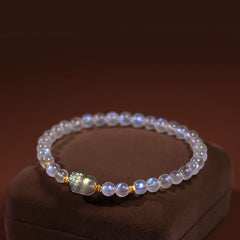 Moonstone PiXiu Bracelet – Luminous moonstone beads with gold PiXiu charm on velvet stand, healing bracelet