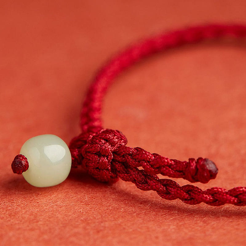 Jade Peace Buckle Lotus Bracelet – extreme close-up of Chinese knot and jade bead on red cord, Artisan