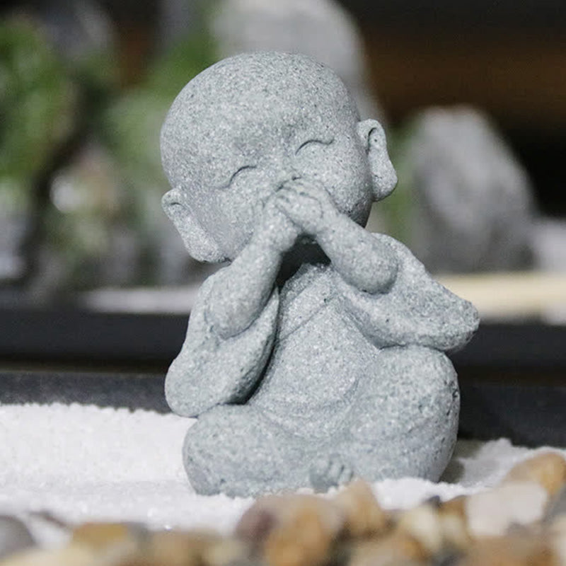 Meditation Monk Statue - Speak no evil monk covering mouth, seated on pebble stones