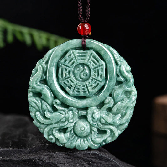 Dragon Jade Yin Yang Necklace – Mottled green jade disc pendant on dark cord with red bead, dark stone surface with green foliage blur, frontal view