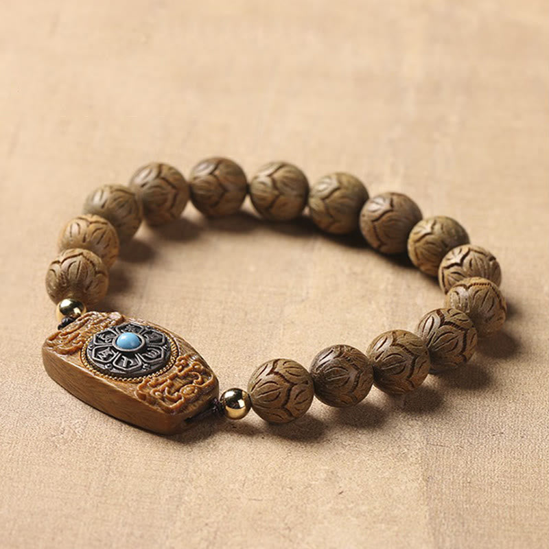 Green Sandalwood & Ebony Soothing Bracelet – three-quarter view on neutral linen, wooden prayer beads with silver medallio...