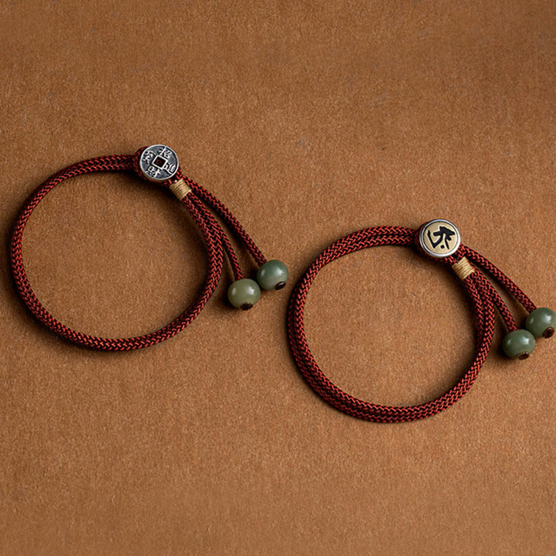 925 Silver Zodiac Natal Buddha Red String Bracelet pair flat lay, two matching burgundy cord bracelets with jade beads, Chinese coin charm with prosperity characters and home symbol, couples friendship bracelet set