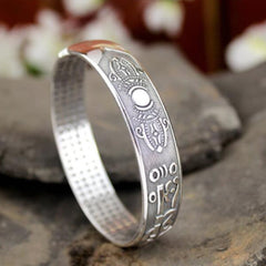 Tibetan silver prayer bangle with antique oxidized finish, lotus throne engraving, vajra motifs, Tibetan script mantra, and micro-dot interior texture.