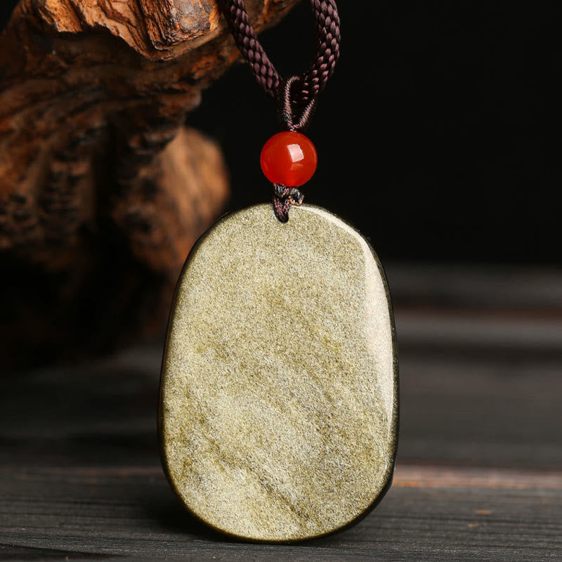 Gold Sheen Obsidian Dragon Pendant – Polished cushion stone with chatoyant surface on rustic wood, grounding