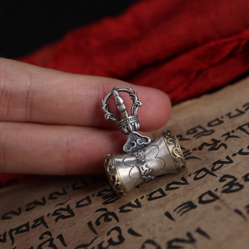 925 Silver Dorje Bell Pendant – Mantra prayer wheel held in fingers against red fabric and sutra