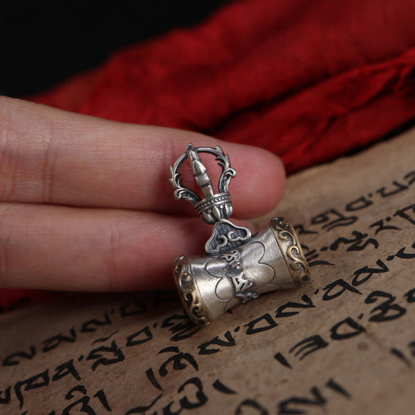 925 Silver Dorje Bell Pendant – Mantra prayer wheel held in fingers against red fabric and sutra