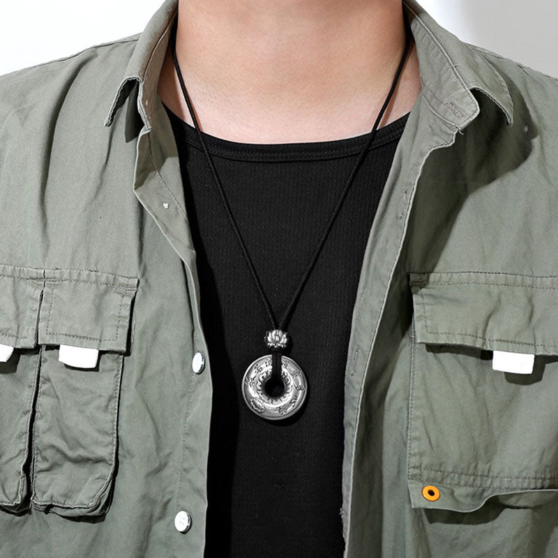 Silver Heart Sutra Pendant – engraved disc with lotus on black cord, styled on model in olive shirt, mens jewelry