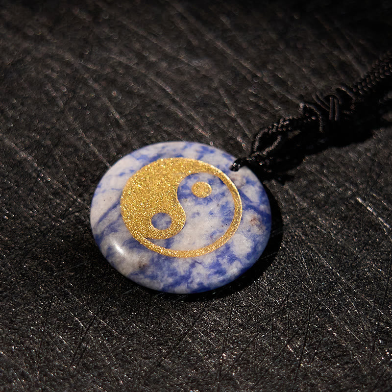 Yin Yang Crystal Necklace – Polished sodalite oval pendant with natural blue and white patterns, smooth domed stone on black 