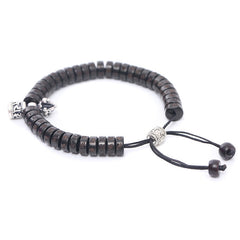 Coconut Shell Dorje Vajra Bracelet – Three-quarter angle showing dark disc beads with silver-toned engraved accents, adjus...