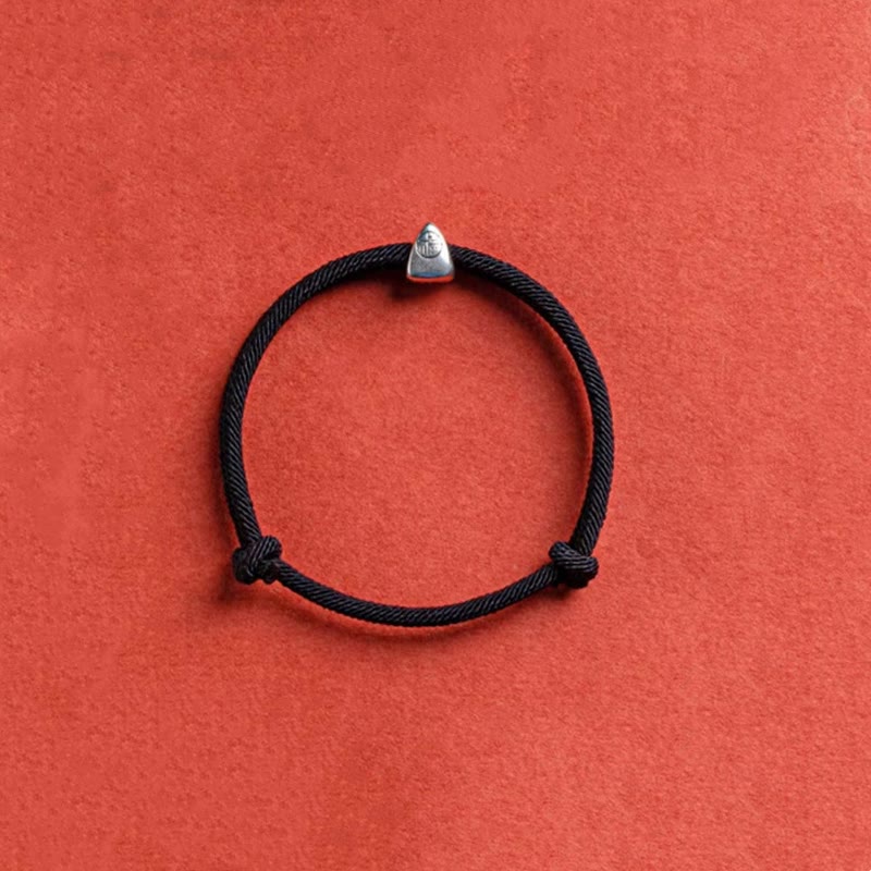 925 Silver Fu Character Braided Bracelet – Black cord bracelet with silver geometric charm and sliding knot on terracotta orange background, overhead flat lay