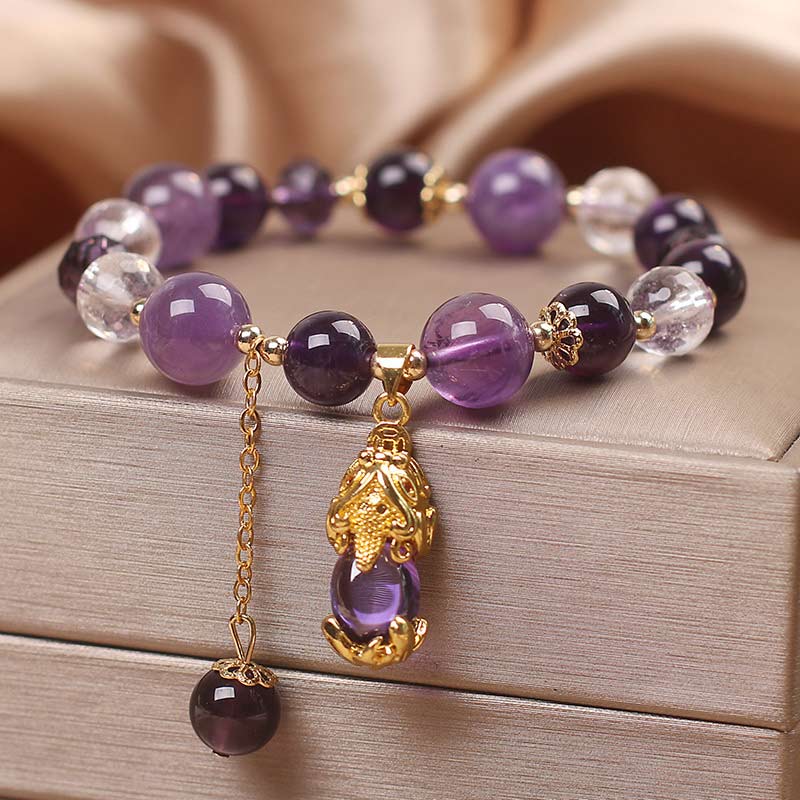 Natural Amethyst PiXiu Healing Bracelet – angled view showing amethyst gradient beads and gold PiXiu charm with dangling purple bead, feng shui