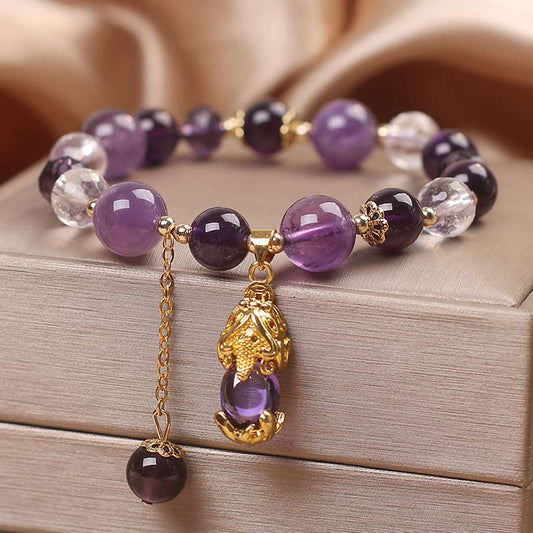 Natural Amethyst PiXiu Healing Bracelet – angled view showing amethyst gradient beads and gold PiXiu charm with dangling purple bead, feng shui