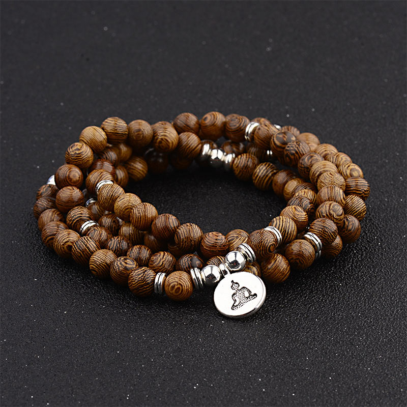 Tibetan Lightning Strike Wood Mala – triple-wrap with Buddha charm on black studio surface
