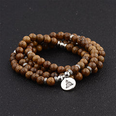 Tibetan Lightning Strike Wood Mala – triple-wrap with Buddha charm on black studio surface