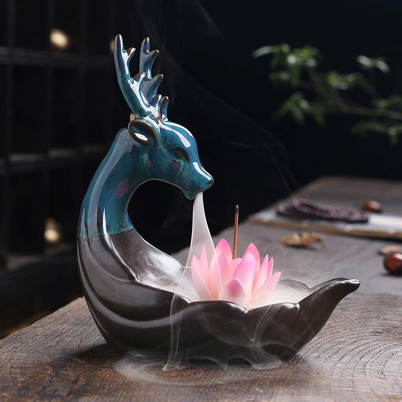 Little Deer Ceramic Lotus Incense Burner – Iridescent teal deer with pink lotus, cascading smoke on wood, backflow incense